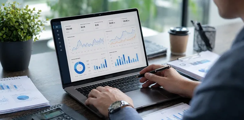 Marketing performance dashboard on laptop showing dental implant ROI tracking with analytics charts and conversion data